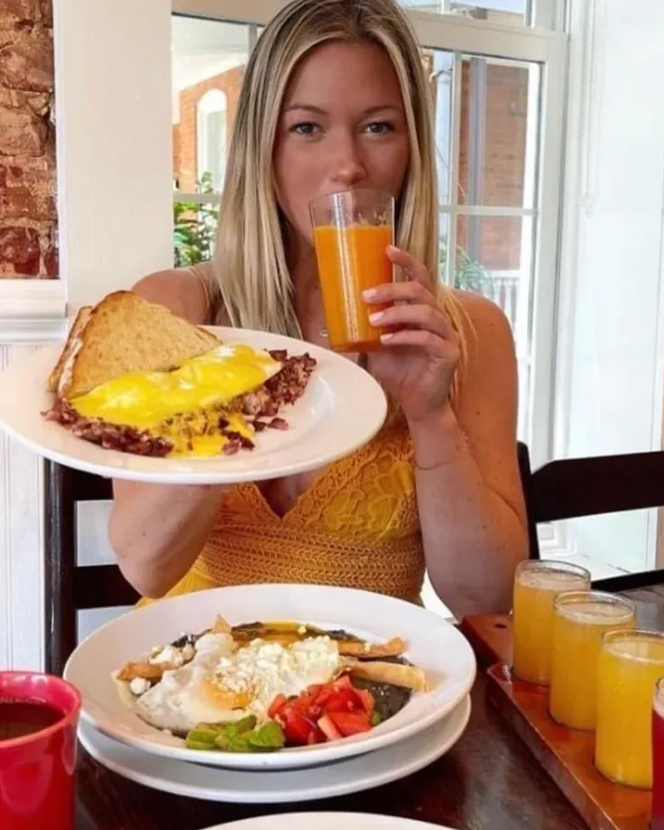 A Famous Toastery guest enjoying breakfast and orange juice